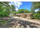 Single-story home with a gravel driveway and surrounded by lush trees at 191 White Oak Church Rd, Dallas, GA 30157