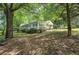 Quaint home nestled among lush trees on a verdant lot with a covered porch at 191 White Oak Church Rd, Dallas, GA 30157