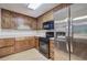 Traditional kitchen features knotty wood cabinets, laminate counters, and stainless-steel refrigerator at 191 White Oak Church Rd, Dallas, GA 30157