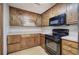 Traditional-style kitchen with knotty wood cabinets, a black oven, and light countertops at 191 White Oak Church Rd, Dallas, GA 30157