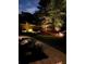 Beautiful landscaped backyard with a winding walkway and custom landscape lighting at night at 2258 Bright Water Dr, Snellville, GA 30078