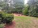 Landscaped backyard featuring a charming fire pit area surrounded by lush greenery and mature trees at 2258 Bright Water Dr, Snellville, GA 30078