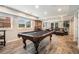 Basement game room featuring a pool table, leather couches, exposed brick, and stylish barstools at 2258 Bright Water Dr, Snellville, GA 30078