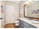 Neutral powder room with wooden framed mirror, granite counters and gray cabinets at 2258 Bright Water Dr, Snellville, GA 30078