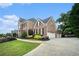 Stately brick home boasting manicured landscaping, a spacious driveway, and a three-car garage at 2258 Bright Water Dr, Snellville, GA 30078