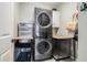 Functional laundry room featuring stacked washer and dryer units, storage and convenient pet kennels at 2258 Bright Water Dr, Snellville, GA 30078