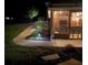 Covered patio with outdoor seating, fan, and a view of landscaped backyard illuminated at night at 2258 Bright Water Dr, Snellville, GA 30078