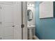 Stylish powder room featuring a pedestal sink, oval mirror, and modern wall art at 82 Hydrangea Cir, Fairburn, GA 30213