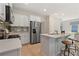 Bright kitchen features stainless steel appliances, white cabinets, and a breakfast bar with counter seating at 82 Hydrangea Cir, Fairburn, GA 30213