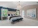 Elegant primary bedroom boasts a tray ceiling, a plush king-size bed, and large windows showcasing scenic views at 82 Hydrangea Cir, Fairburn, GA 30213