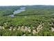 Wide aerial shot showcasing homes nestled among a vast expanse of mature trees with a lake in the distance at 902 Laurel Crest Dr, Woodstock, GA 30189