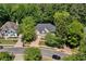 Beautiful aerial view of a traditional home surrounded by mature trees and lush landscaping in a quiet neighborhood at 902 Laurel Crest Dr, Woodstock, GA 30189
