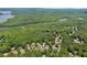 Expansive aerial view showcasing a neighborhood near lush woods and a winding river at 902 Laurel Crest Dr, Woodstock, GA 30189