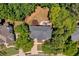 Overhead view of a home showcasing its expansive roof, rear patio, and surrounding mature trees and lush backyard at 902 Laurel Crest Dr, Woodstock, GA 30189