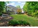 Expansive backyard featuring a lush lawn, fire pit, deck, and mature trees for privacy at 902 Laurel Crest Dr, Woodstock, GA 30189