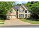 Charming two-story home featuring a three-car garage, lush lawn, and manicured landscaping at 902 Laurel Crest Dr, Woodstock, GA 30189