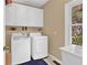 Bright laundry room equipped with washer, dryer, utility sink, and ample storage at 902 Laurel Crest Dr, Woodstock, GA 30189