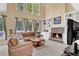 Bright living room with stone fireplace, built-in bookshelves, large sofa and many windows overlooking the backyard at 902 Laurel Crest Dr, Woodstock, GA 30189