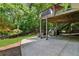 A covered patio and spacious backyard bordered by mature trees offers privacy and outdoor enjoyment at 902 Laurel Crest Dr, Woodstock, GA 30189