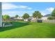 Backyard with a well-maintained lawn, mature trees, and patio seating area at 160 Oak Manor Dr, Covington, GA 30016