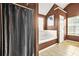 Bathroom featuring a shower curtain, soaking tub, and tile floors at 160 Oak Manor Dr, Covington, GA 30016