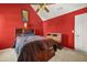Red bedroom featuring a queen bed, ceiling fan, and ample closet space at 160 Oak Manor Dr, Covington, GA 30016