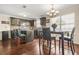 Modern kitchen with wood floors, dark cabinets, granite counters, stainless appliances, and seating at island at 160 Oak Manor Dr, Covington, GA 30016