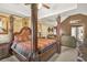 Comfortable main bedroom boasts a four-poster bed and sitting area with abundant natural light at 160 Oak Manor Dr, Covington, GA 30016