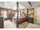 Spacious main bedroom features a four-poster bed, tray ceiling, and warm, inviting decor at 160 Oak Manor Dr, Covington, GA 30016