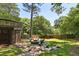 Lush backyard features a stone patio with a fire pit, seating area, and mature trees for shade at 382 Lofton Nw Rd, Atlanta, GA 30309