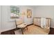 Bright Bedroom features a modern crib, stylish chair, decor, and a large window overlooking the yard at 382 Lofton Nw Rd, Atlanta, GA 30309