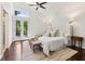Bright main bedroom featuring French doors, large windows, ceiling fan, and hardwood floors at 382 Lofton Nw Rd, Atlanta, GA 30309