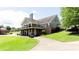 Two-story home with a large deck, brick accents, and lush green lawn leading to a paved driveway at 6505 Hampton Creek Dr, Cumming, GA 30041