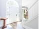 Bright foyer featuring hardwood floors, elegant staircase, and views into the formal dining room at 6505 Hampton Creek Dr, Cumming, GA 30041