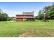 Expansive backyard featuring lush lawn, mature trees, fenced perimeter, playset and screened in porch at 117 Constance Dr, Locust Grove, GA 30248