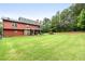 Expansive backyard featuring lush lawn, mature trees, fenced perimeter, playset and screened in porch at 117 Constance Dr, Locust Grove, GA 30248