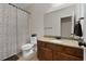 Bathroom with granite countertop, wood cabinets, patterned shower curtain, and tile flooring at 117 Constance Dr, Locust Grove, GA 30248