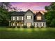 Charming home featuring brick and vinyl siding, a well-manicured lawn, and mature trees at twilight at 117 Constance Dr, Locust Grove, GA 30248