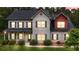 Dusk view of a charming two-story home featuring a brick facade and mature landscaping at 117 Constance Dr, Locust Grove, GA 30248