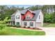 Side view of a charming two-story home featuring a brick facade, a well-maintained lawn and mature landscaping at 117 Constance Dr, Locust Grove, GA 30248
