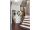 Elegant foyer featuring hardwood floors, a staircase with decorative wrought iron spindles, and a view into other rooms at 117 Constance Dr, Locust Grove, GA 30248