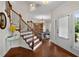 Elegant foyer featuring hardwood floors, a staircase with decorative wrought iron spindles, and a glass front door at 117 Constance Dr, Locust Grove, GA 30248
