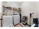 Bright laundry room with washer, dryer, and convenient storage shelving at 117 Constance Dr, Locust Grove, GA 30248
