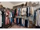 Well-organized walk-in closet with rods and shelves full of clothing, handbags and shoes at 117 Constance Dr, Locust Grove, GA 30248