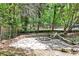 Cozy backyard fire pit area with stone patio and bench seating, surrounded by lush greenery at 1986 N Decatur Ne Rd, Atlanta, GA 30307