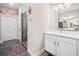 Bathroom featuring a single sink vanity, decorative wall art, and a glass enclosed shower at 410 Gardens Of Harmony Dr, Canton, GA 30115