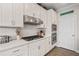 Stylish kitchen with white cabinets, stainless steel appliances, and modern subway tile backsplash at 410 Gardens Of Harmony Dr, Canton, GA 30115