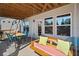 Covered patio seating area includes an outdoor swing and dining table at 410 Gardens Of Harmony Dr, Canton, GA 30115