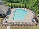 Aerial view of the community pool with lounge chairs and tables surrounded by lush landscaping at 410 Gardens Of Harmony Dr, Canton, GA 30115