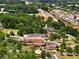 Aerial view shows a community surrounded by lush greenery, roads, and parking lots at 4905 Sterling Close, Buford, GA 30518
